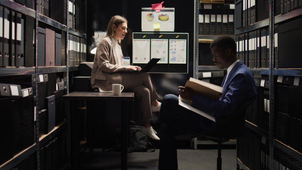 Business professionals discussing data in a server room.